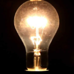 A glowing light bulb illuminates against a dark background.