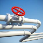 3d illustration of white industrial pipes with a prominent red valve against a blue sky background.