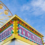 Colorful carnival ticket booth and ferris wheel