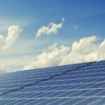 Solar panels reflecting sunlight under blue sky